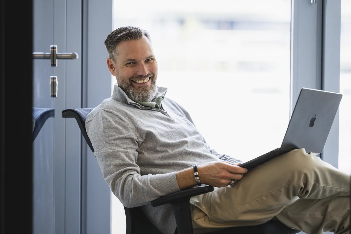 Tobias Dolgener, lächelnd mit Laptop